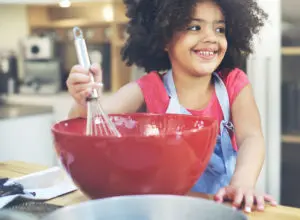 toddler girl looking distressingly at a piece of broccoli on a fork