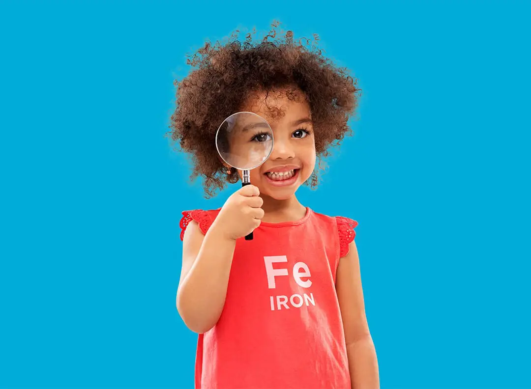 toddler girl looking distressingly at a piece of broccoli on a fork